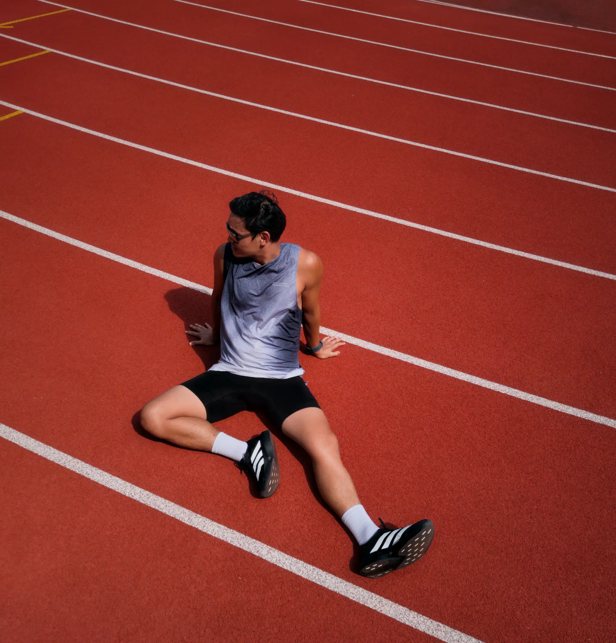 Runner resting on a red track