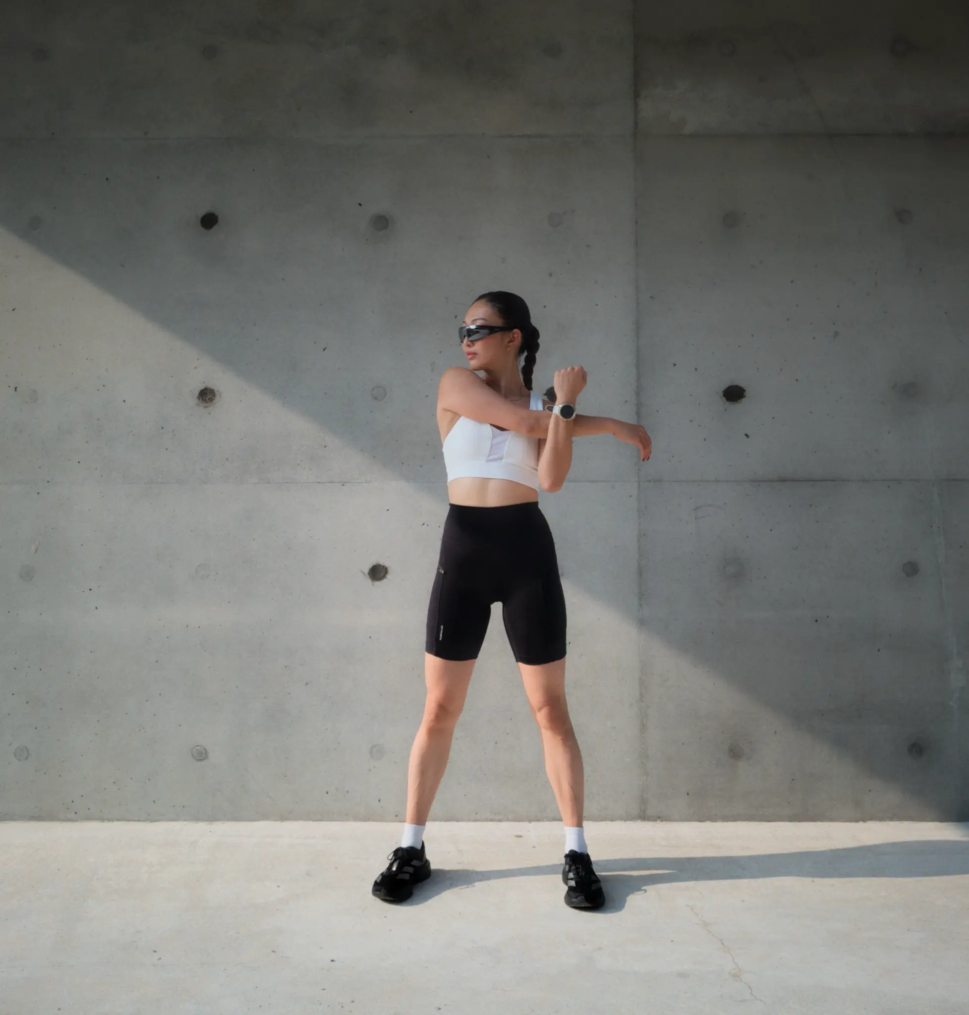 Runner warming up against a concrete wall